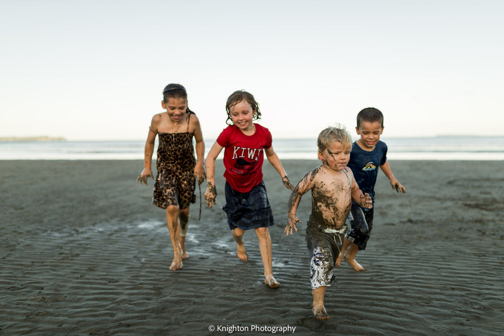 Friends playing at the beach at sunset Friends playing at the beach at sunset
